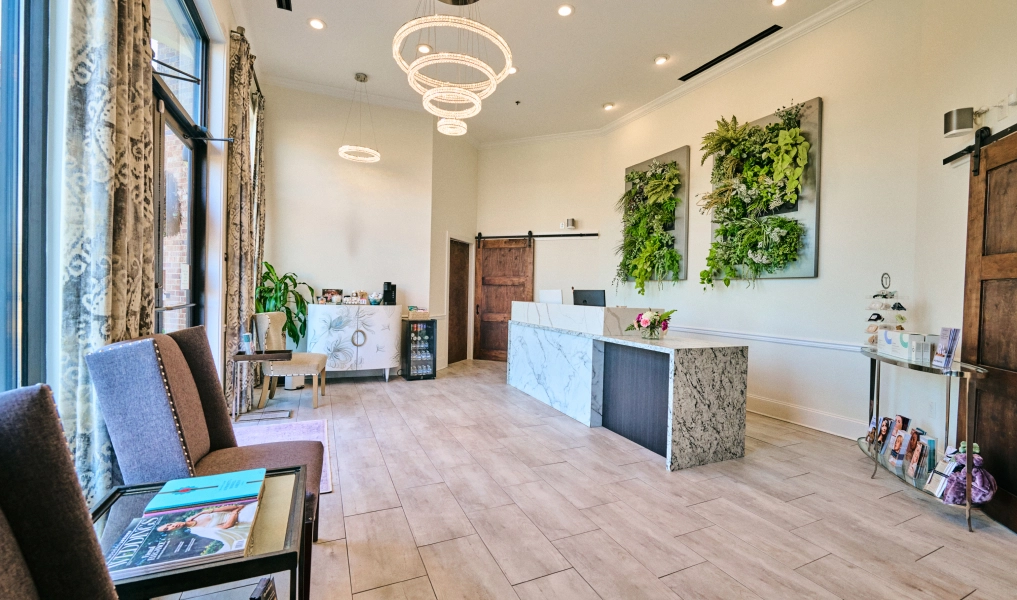 Modern dental office reception area with bright natural light, elegant chandelier, and contemporary furniture - in Alpharetta, GA