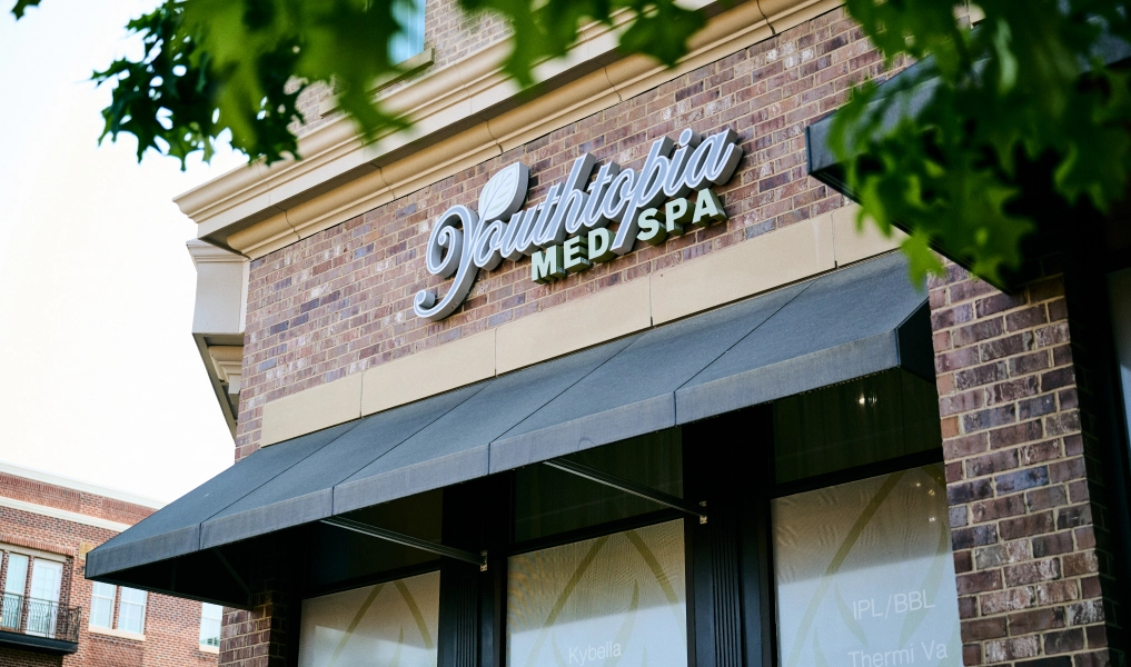Victoria Med Spa exterior entrance with brick facade and awning surrounded by trees - in Alpharetta, GA