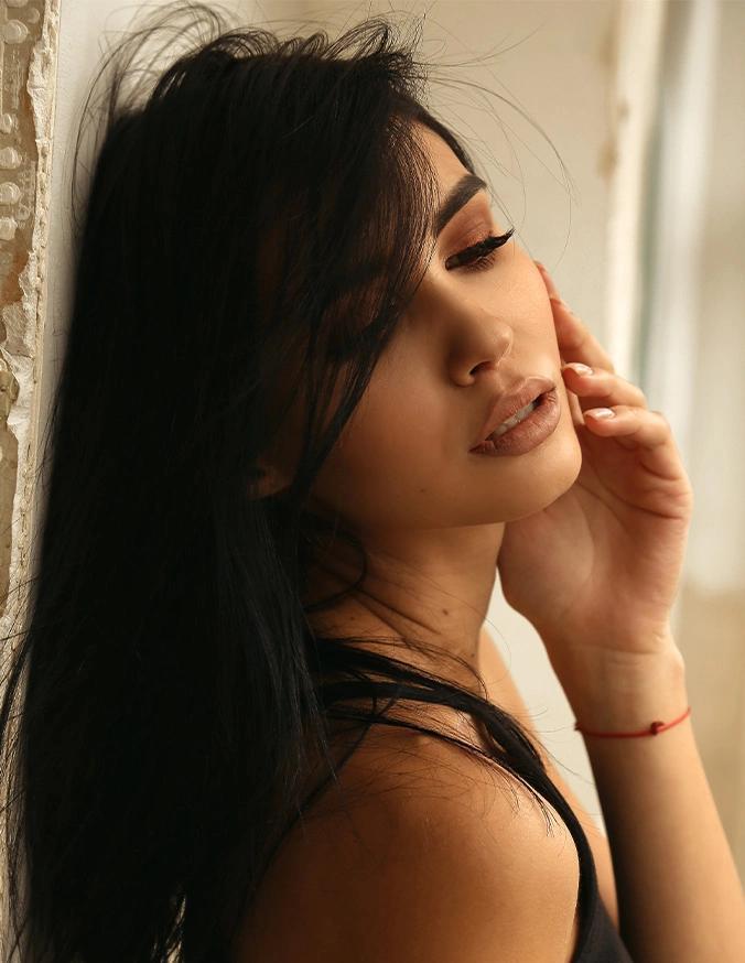 Woman with dark hair in profile pose with hand near face, soft natural lighting - Diamond glow in Alpharetta, GA