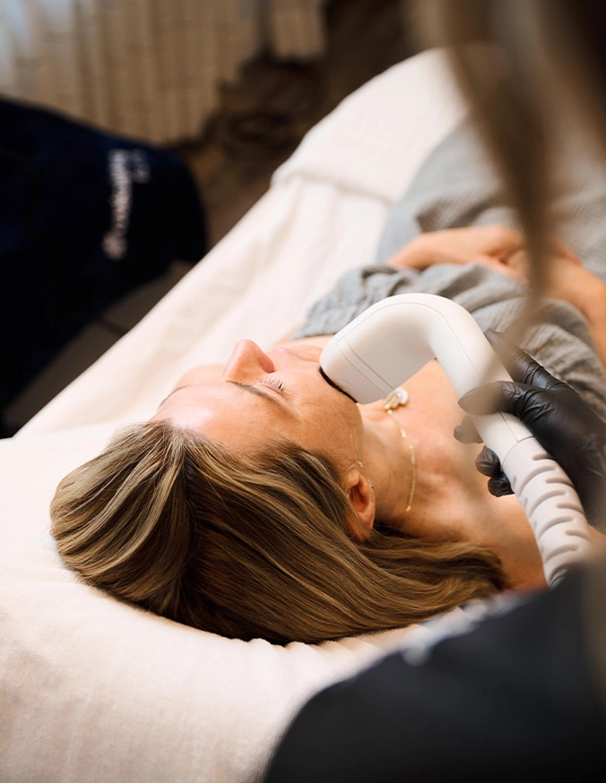 Woman receiving facial treatment at spa while lying on treatment bed in relaxation - Sofwave in Alpharetta, GA